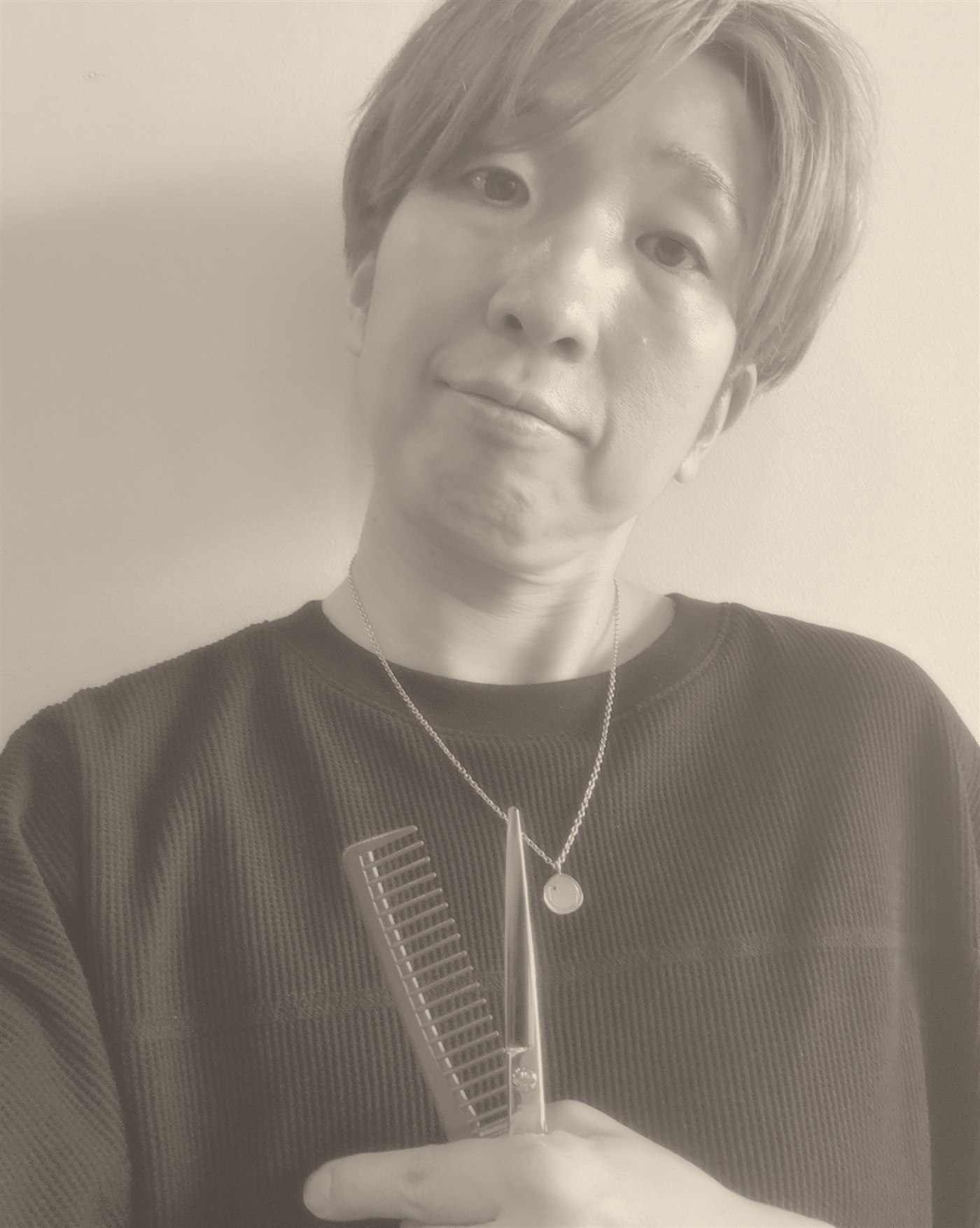 INOSENSE監修美容師(髪のソムリエ)の顔写真、コームとシザーを手にした構図